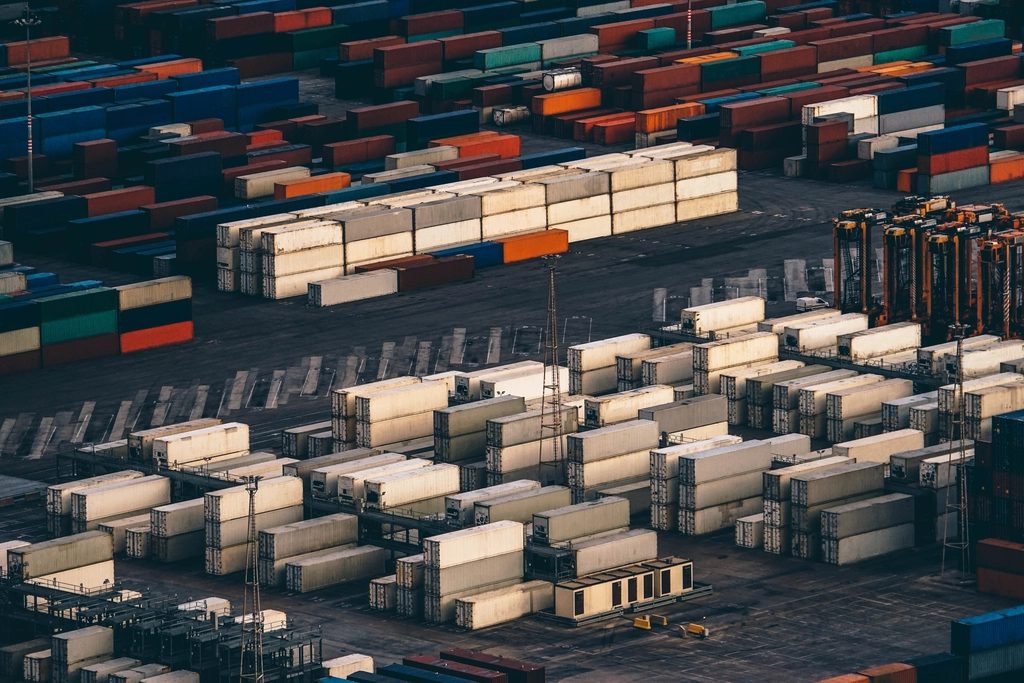 Aerial view of shipping containers stacked in a port terminal yard