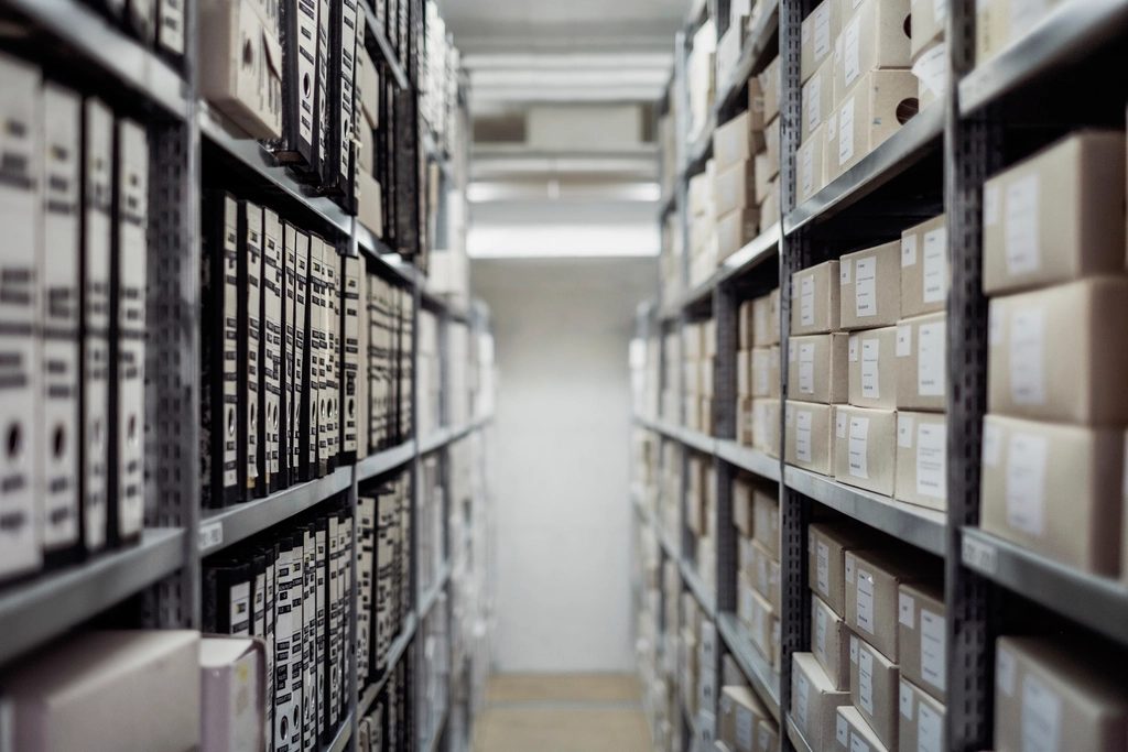 Aisle of archive shelving stacked with binders and boxes